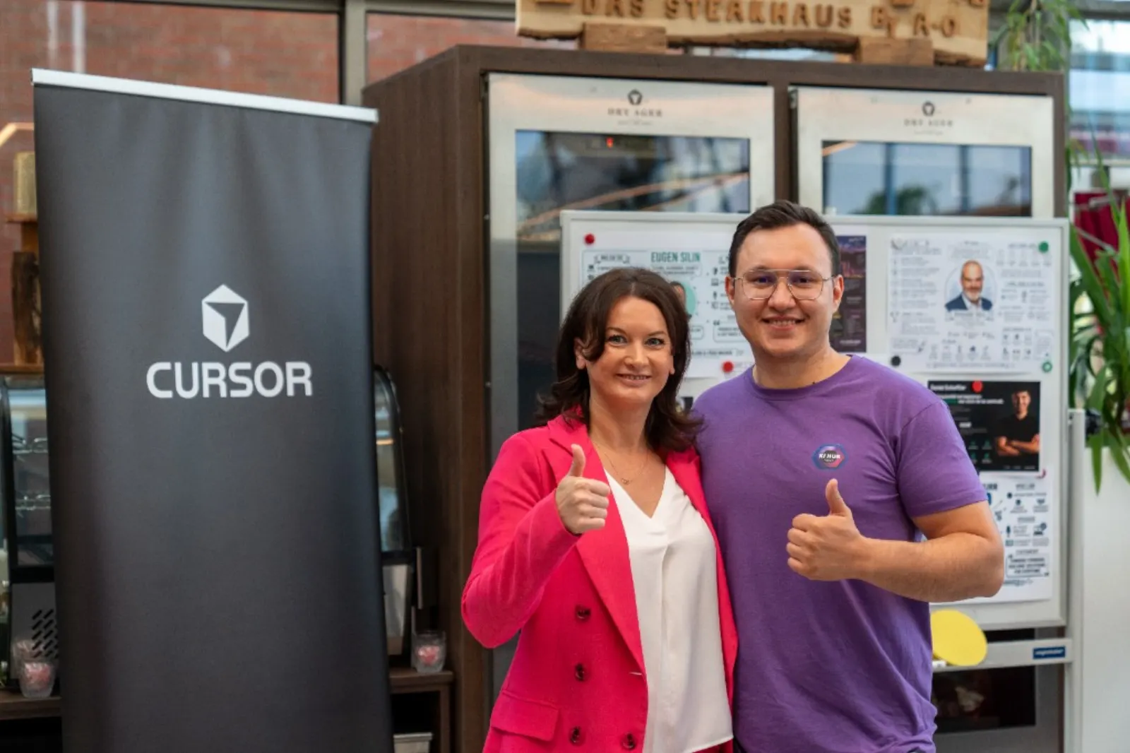 Cursor Kassel Build Day, zwei Hosts mit Daumen hoch vor dem Cursor-Banner