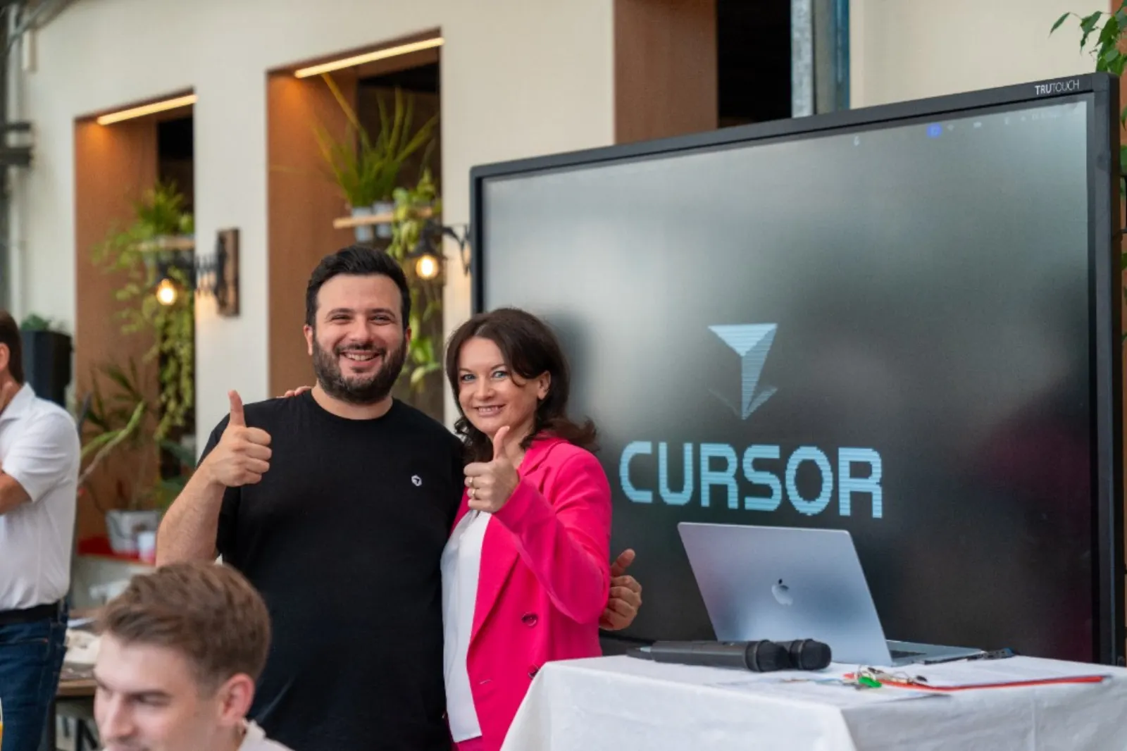 Cursor Kassel Build Day, Daumen hoch vor dem Cursor-Schriftzug auf dem Screen